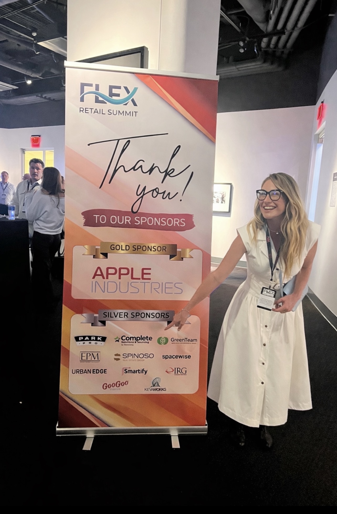 Modern Client founder Michelle Fitzgerald at the Gold Sponsor board at FLEX Retail Summit 2026, with Apple Industries as Gold Sponsor.